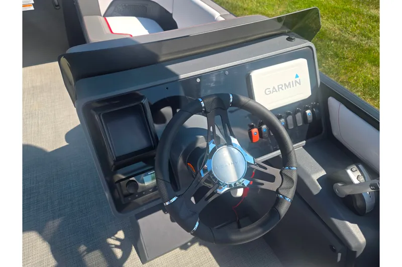 Slide: The Image of 2024 Manitou Cruise boat dashboard with Garmin navigation system and steering wheel. - 20