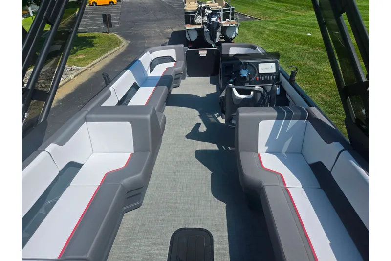 Slide: The Image of 2024 Manitou Cruise pontoon boat interior with modern seating and steering console. - 17