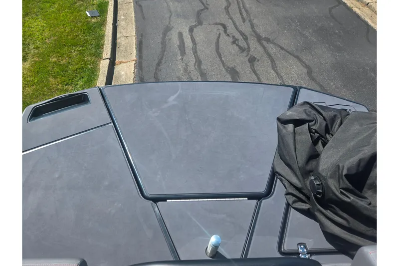 Slide: The Image of 2024 Manitou Cruise boat deck with cover and bottle, parked on asphalt. - 15