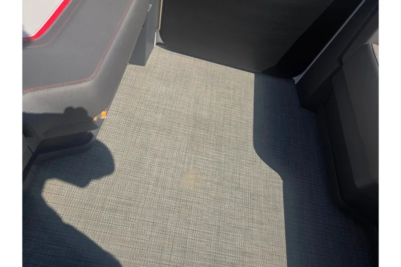 Slide: The Image of 2024 Manitou Cruise interior flooring with gray textured carpet and seating. - 23