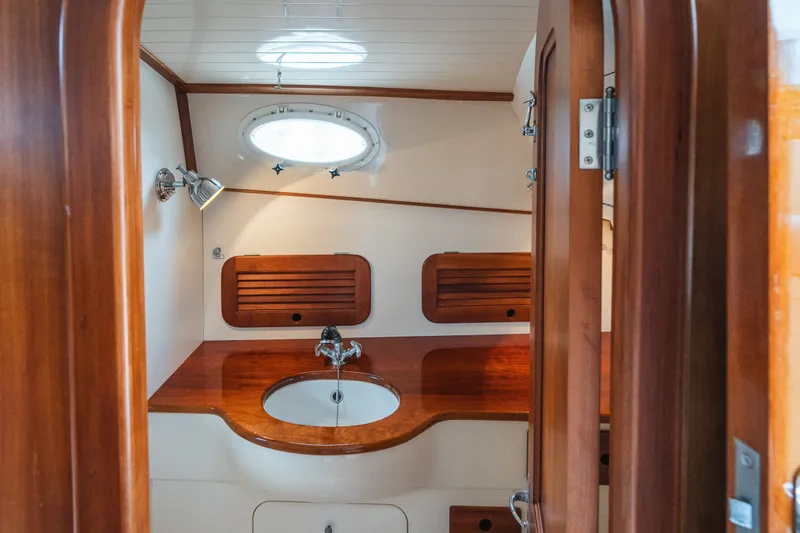 Slide: The Image of Hinckley Picnic Boat 36 Classic 2000 bathroom with wooden cabinetry and round sink. - 58
