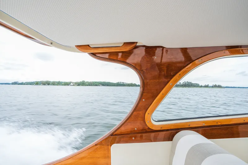 Slide: The Image of Interior view of 2000 Hinckley Picnic Boat 36 Classic, showcasing elegant woodwork and scenic waterway. - 40