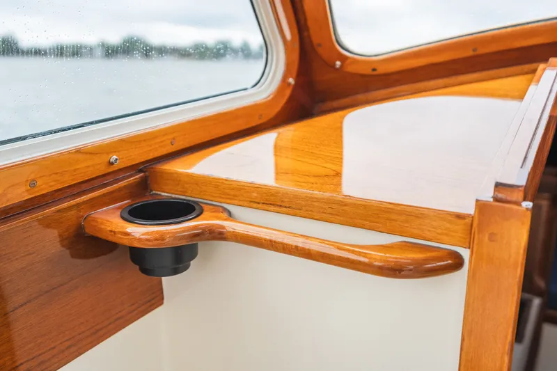 Slide: The Image of Interior of 2000 Hinckley Picnic Boat 36 Classic with polished wood finish and cup holder. - 45