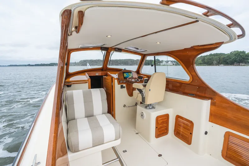Slide: The Image of Interior of 2000 Hinckley Picnic Boat 36 Classic with elegant wood finish and striped seating. - 25