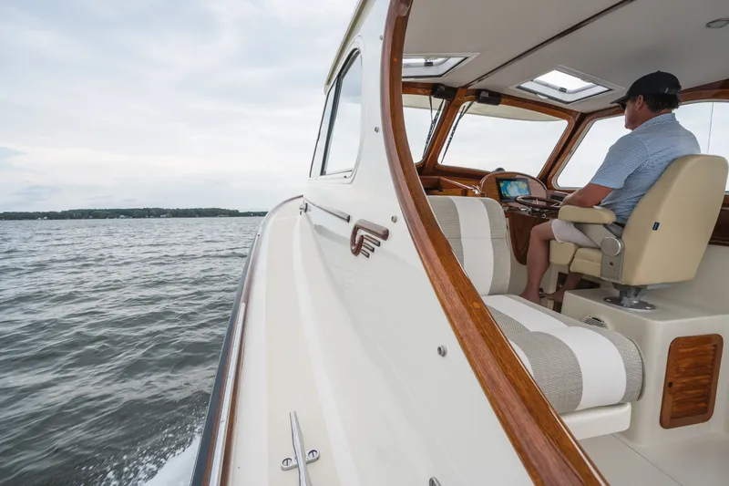 Slide: The Image of 2000 Hinckley Picnic Boat 36 Classic cruising on open water, interior view with captain. - 21