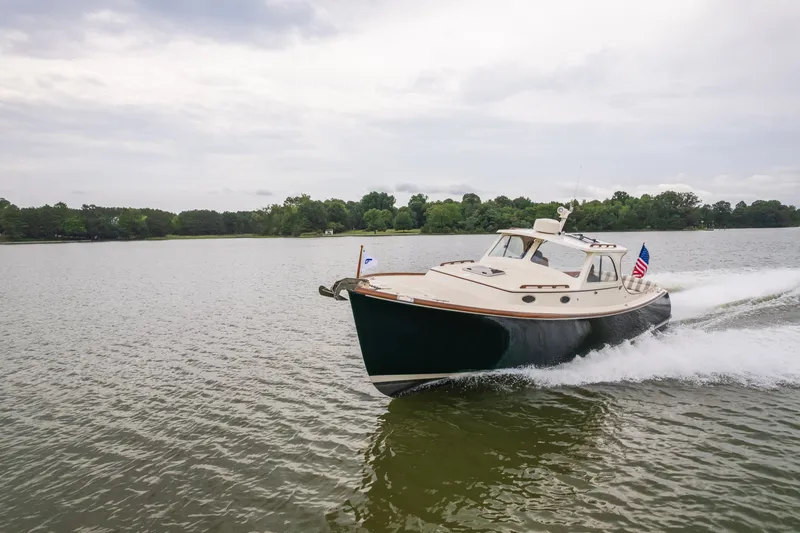 Slide: The Image of 2000 Hinckley Picnic Boat 36 Classic cruising on a serene lake under cloudy skies. - 15