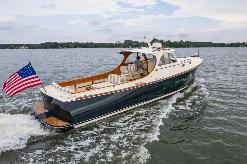 Slide: The Image of Hinckley Picnic Boat 36 Classic 2000 cruising on a lake with American flag. - 11