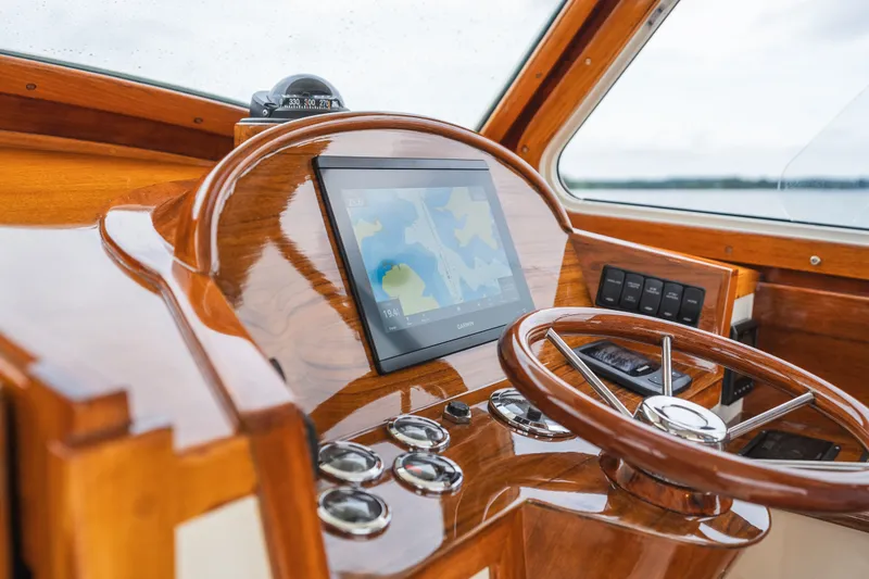 Slide: The Image of Hinckley Picnic Boat 36 Classic 2000 helm with wooden steering wheel and navigation display. - 5