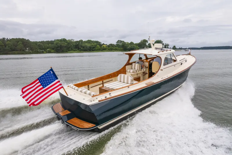 Slide: The Image of 2000 Hinckley Picnic Boat 36 Classic cruising on a lake with American flag. - 65