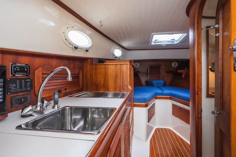 Slide: The Image of Interior of 2000 Hinckley Picnic Boat 36 Classic, featuring a cozy cabin with wood finishes. - 48