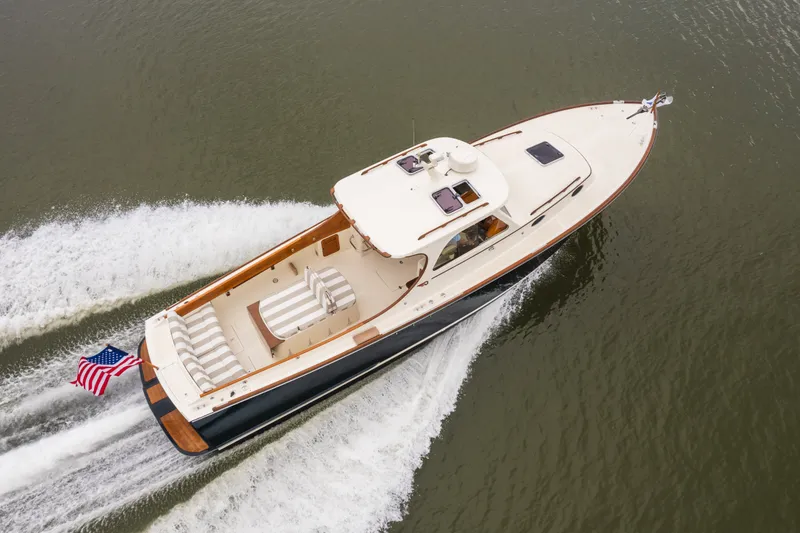 Slide: The Image of Hinckley Picnic Boat 36 Classic, 2000 model, cruising on water with American flag. - 18