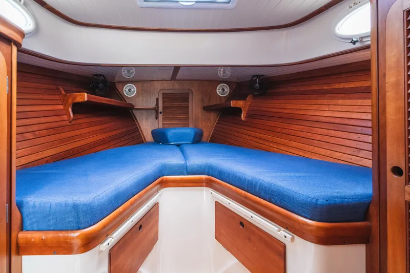 Slide: The Image of 2000 Hinckley Picnic Boat 36 Classic cabin with blue cushions and wooden interior. - 50