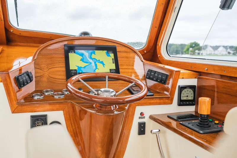 Slide: The Image of Helm of 2000 Hinckley Picnic Boat 36 Classic with navigation display and wooden steering wheel. - 30