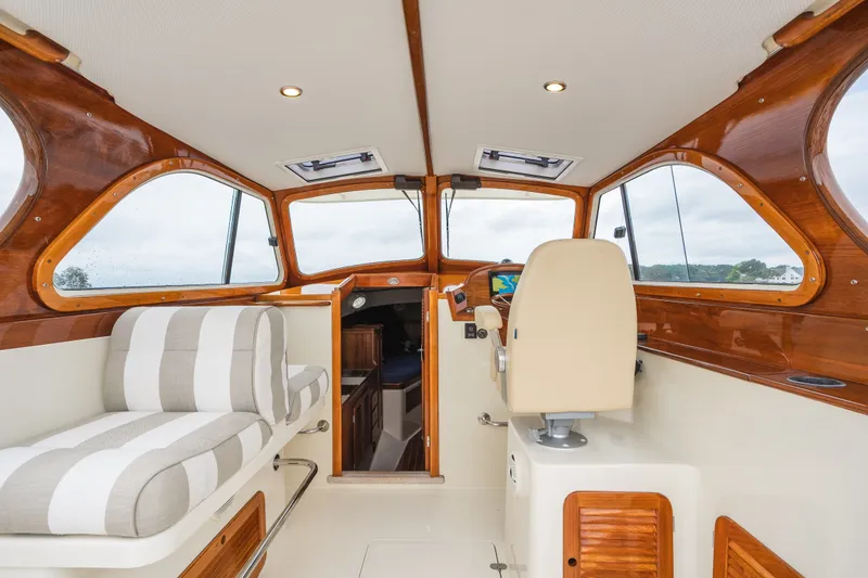 Slide: The Image of Interior of 2000 Hinckley Picnic Boat 36 Classic with elegant wood finish and striped seating. - 26