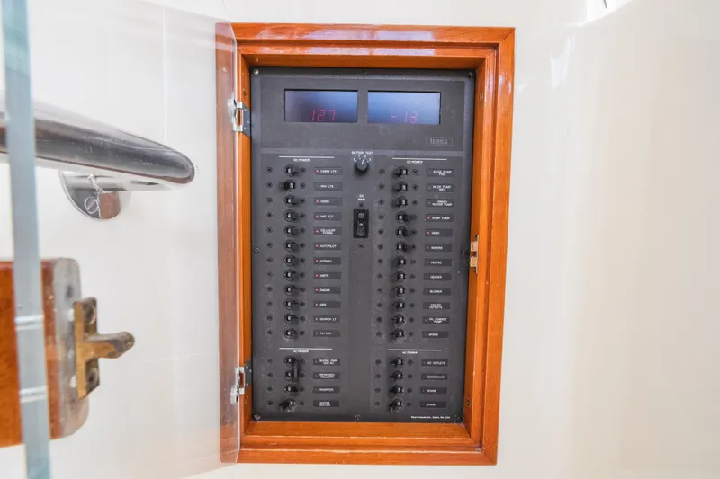 Slide: The Image of Electrical panel on a 2000 Hinckley Picnic Boat 36 Classic, featuring switches and digital display. - 62
