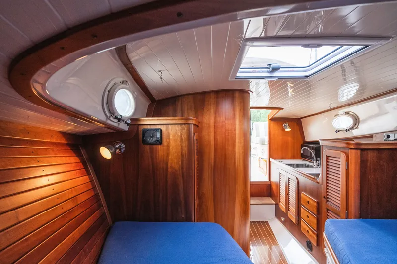 Slide: The Image of Interior of 2000 Hinckley Picnic Boat 36 Classic with wood paneling and blue seating. - 54