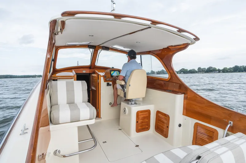 Slide: The Image of 2000 Hinckley Picnic Boat 36 Classic cruising on open water, featuring elegant woodwork and striped seating. - 19