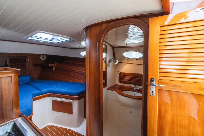 Slide: The Image of Interior of 2000 Hinckley Picnic Boat 36 Classic with wood finish and blue seating. - 56
