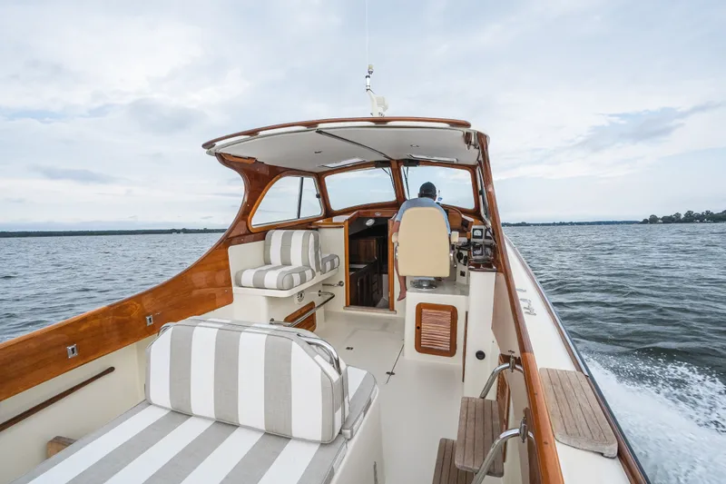 Slide: The Image of 2000 Hinckley Picnic Boat 36 Classic cruising on open water, featuring elegant wooden interior. - 20