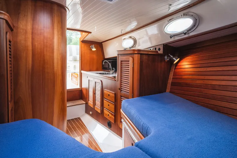 Slide: The Image of Interior of 2000 Hinckley Picnic Boat 36 Classic with wood paneling and blue upholstery. - 51