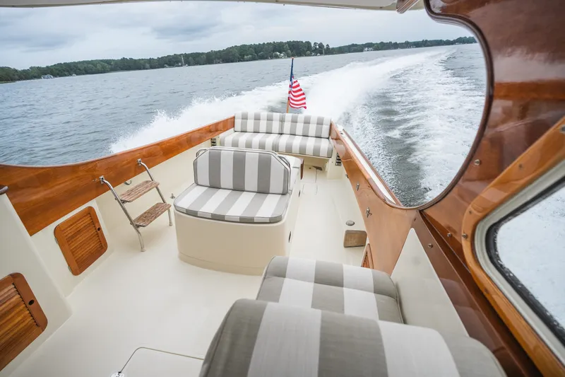 Slide: The Image of 2000 Hinckley Picnic Boat 36 Classic cruising on water, featuring elegant striped seating. - 41