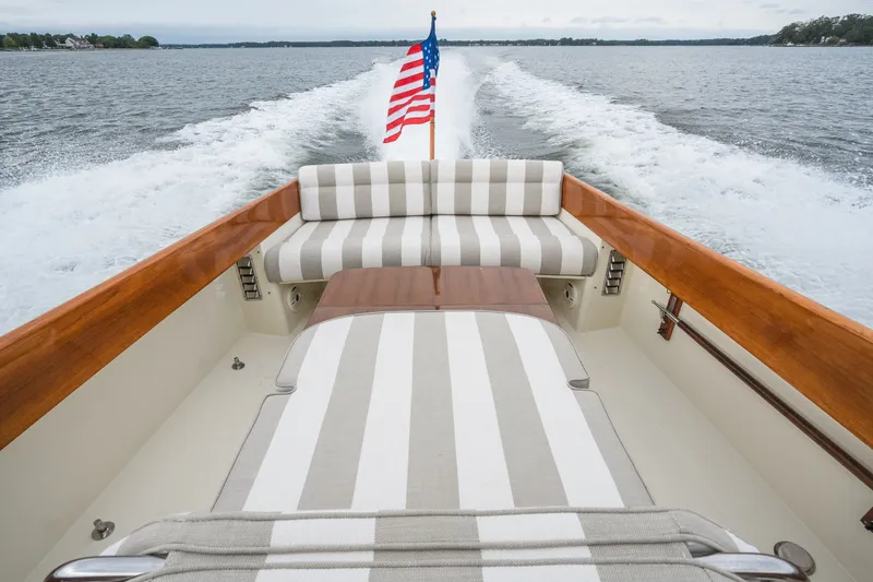 Slide: The Image of Hinckley Picnic Boat 36 Classic, 2000 model, cruising with American flag, striped seating, and wooden accents. - 23