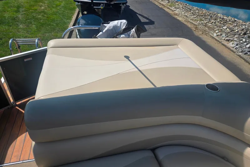 Slide: The Image of Rear seating area of a 2012 Manitou 25 Legacy pontoon boat, featuring beige upholstery. - 16