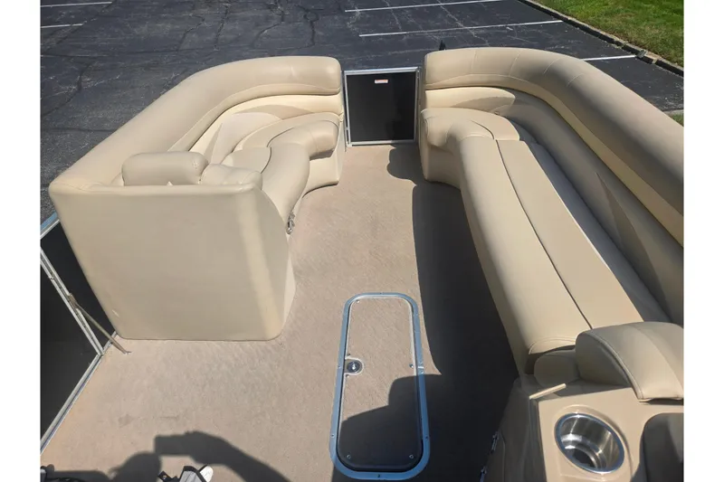 Slide: The Image of 2012 Manitou 25 Legacy pontoon boat with beige seating and spacious interior. - 24