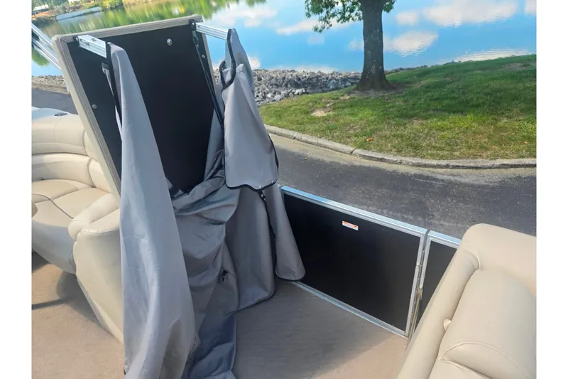 Slide: The Image of 2012 Manitou 25 Legacy boat interior with seating and storage compartment. - 11