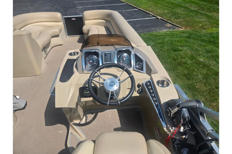 Slide: The Image of 2012 Manitou 25 Legacy boat interior with steering wheel and dashboard controls. - 23