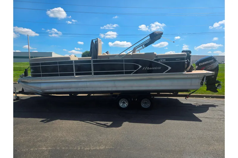 Slide: The Image of 2012 Manitou 25 Legacy pontoon boat on trailer under a clear blue sky. - 4