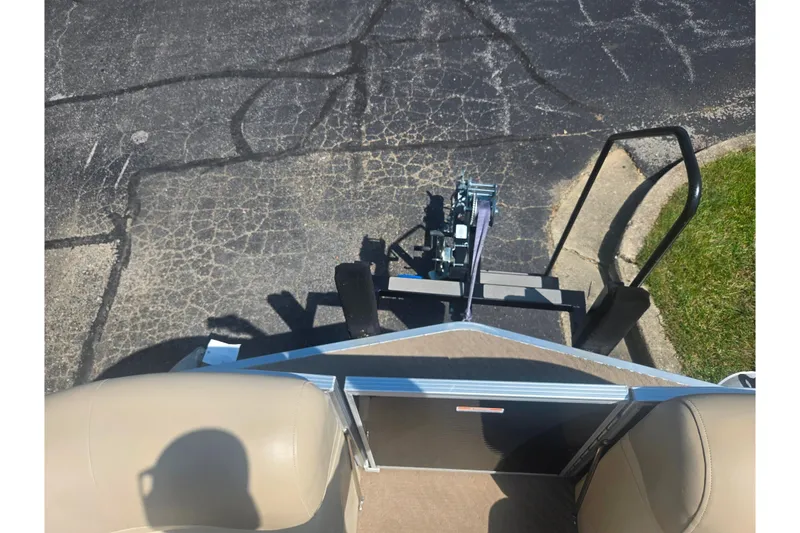 Slide: The Image of 2012 Manitou 25 Legacy boat interior with beige seating and trailer hitch. - 26