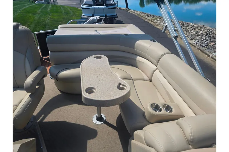Slide: The Image of Luxurious seating on 2012 Manitou 25 Legacy pontoon boat with beige upholstery and table. - 13
