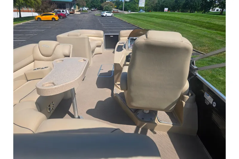 Slide: The Image of 2012 Manitou 25 Legacy pontoon boat interior with beige seating and table. - 21