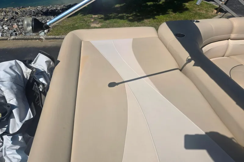 Slide: The Image of Beige seating on 2012 Manitou 25 Legacy boat, with shadow and water view. - 19