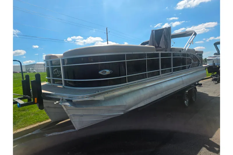 Slide: The Image of 2012 Manitou 25 Legacy pontoon boat on trailer under a clear blue sky. - 5