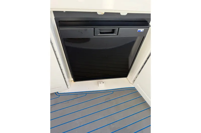 Slide: The Image of Black refrigerator on 2002 Sea Ray 340 Sundancer boat with striped flooring. - 16