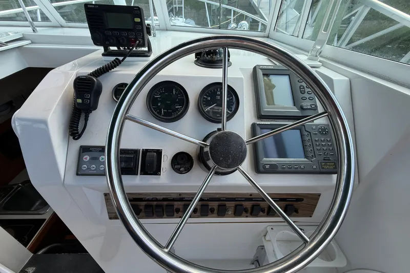 Slide: The Image of Helm of 2000 Mainship Pilot 30 with steering wheel and navigation instruments. - 19