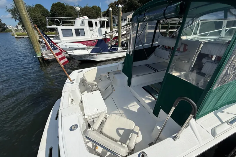Slide: The Image of 2000 Mainship Pilot 30 docked, featuring spacious seating and American flag. - 12