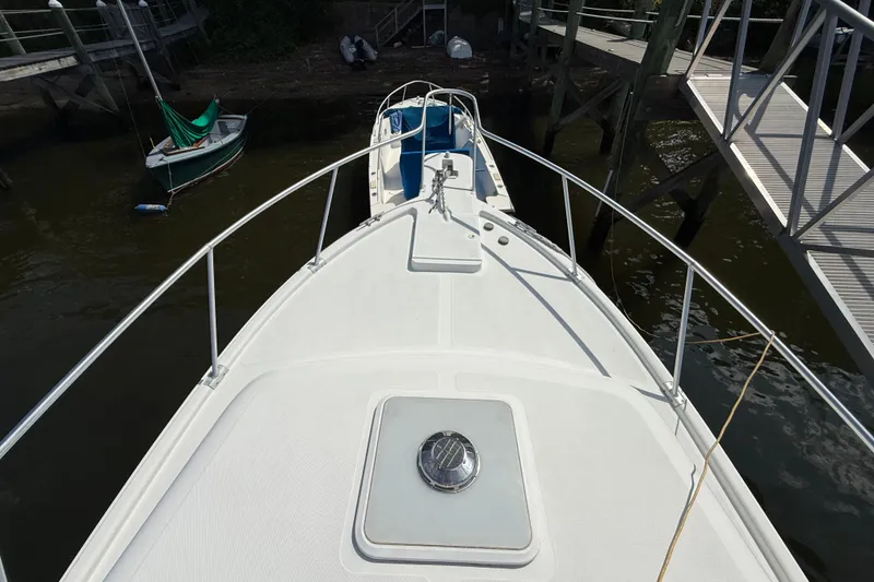 Slide: The Image of Bow view of a 2000 Mainship Pilot 30 docked at a marina. - 5