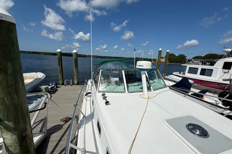 Slide: The Image of 2000 Mainship Pilot 30 docked at a marina under a clear blue sky. - 4