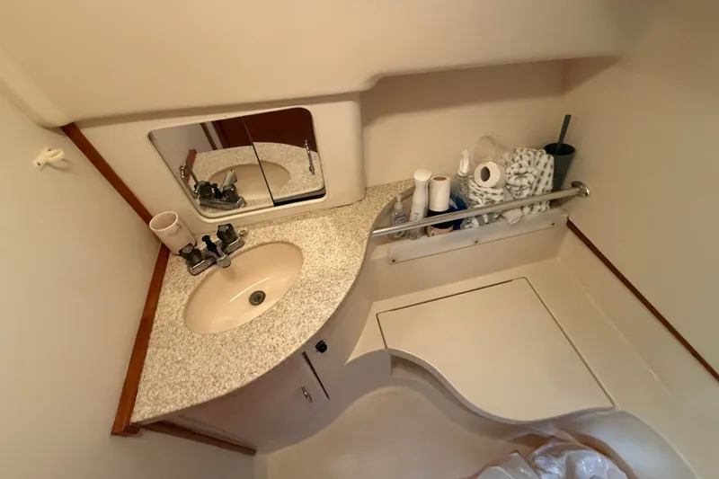 Slide: The Image of Bathroom interior of 2000 Mainship Pilot 30 with sink and storage. - 26