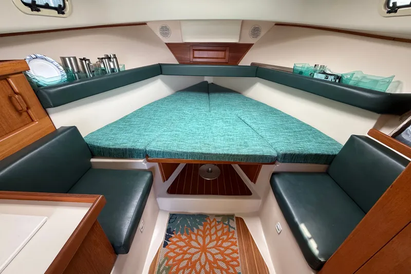 Slide: The Image of Interior of 2000 Mainship Pilot 30 boat with teal seating and wooden accents. - 25