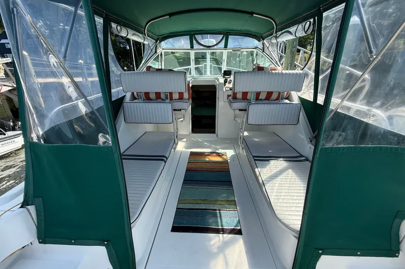 Slide: The Image of Interior view of 2000 Mainship Pilot 30 boat with green canopy and striped cushions. - 13