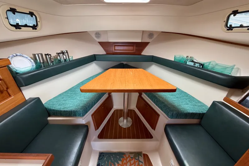 Slide: The Image of Interior of 2000 Mainship Pilot 30 boat with cozy seating and wooden table. - 24