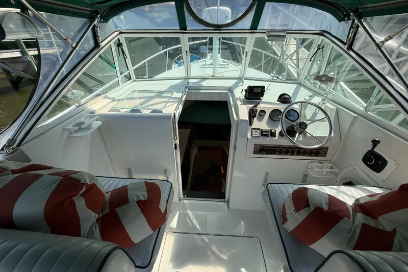 Slide: The Image of Interior view of 2000 Mainship Pilot 30 boat cockpit with steering wheel and striped cushions. - 15