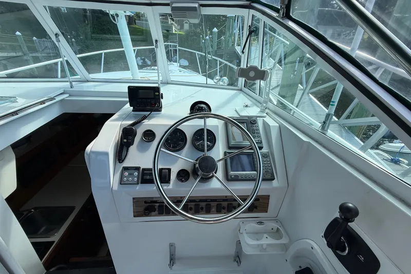 Slide: The Image of Helm of 2000 Mainship Pilot 30 with steering wheel and navigation instruments. - 18