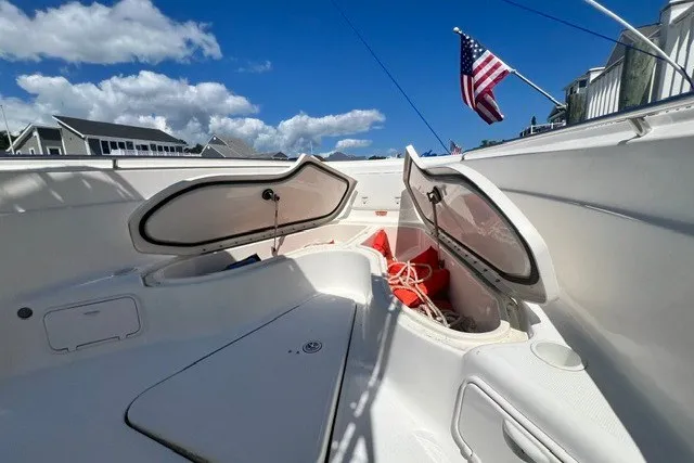 Slide: The Image of 2004 Wellcraft 252 Fisherman boat interior with open storage compartments and American flag. - 10