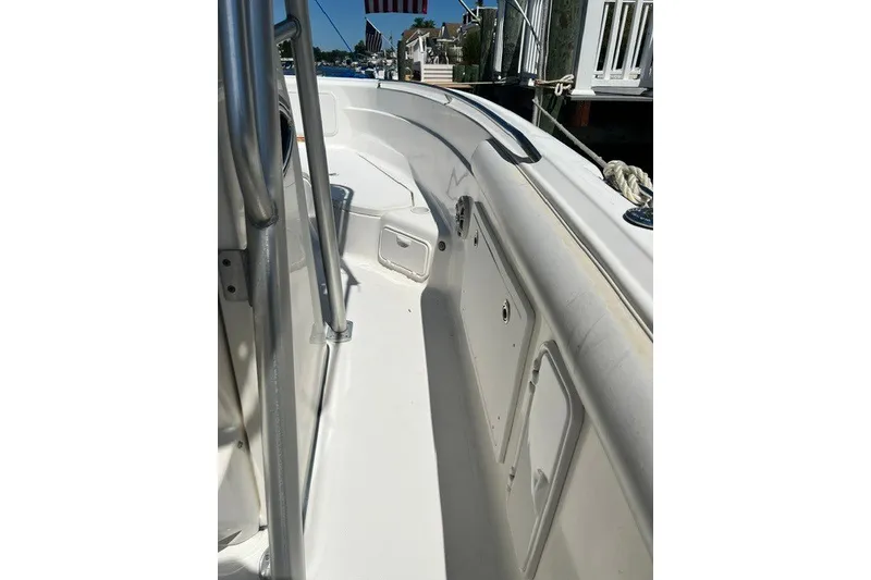 Slide: The Image of 2004 Wellcraft 252 Fisherman boat interior with white seating and storage compartments. - 12