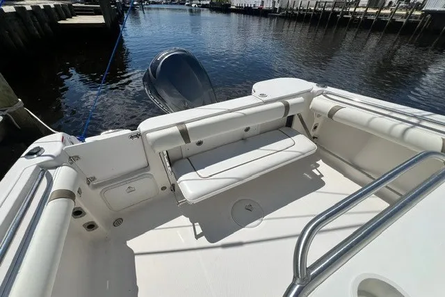 Slide: The Image of 2004 Wellcraft 252 Fisherman boat interior with seating, docked by the water. - 14